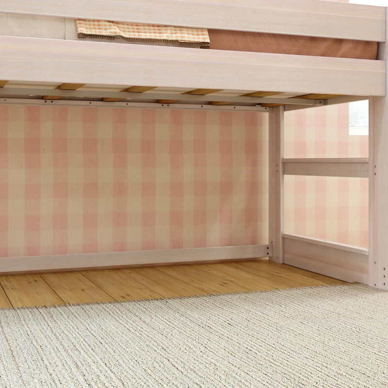 Underneath light wood loft bed with pink gingham wallpaper, hardwood floor and beige textured rug — kids bedroom storage nook