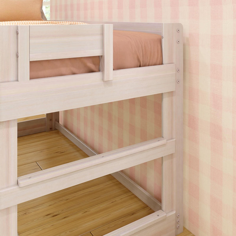 Whitewashed wooden bunk bed close-up with safety rail, beige bedding, pink plaid wallpaper and oak floor in a modern kids' bedroom