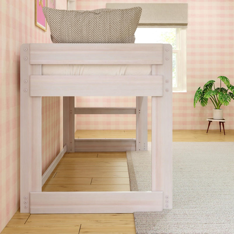 Whitewashed wooden loft bed with chevron pillow against pink gingham wallpaper in a cozy kids' bedroom with hardwood floors, neutral rug and potted plant