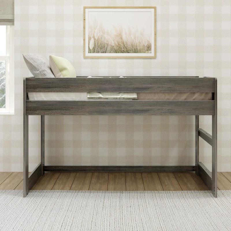 Rustic gray twin loft bed with decorative pillows against beige buffalo-check wallpaper and framed pampas grass print in a neutral kids' bedroom