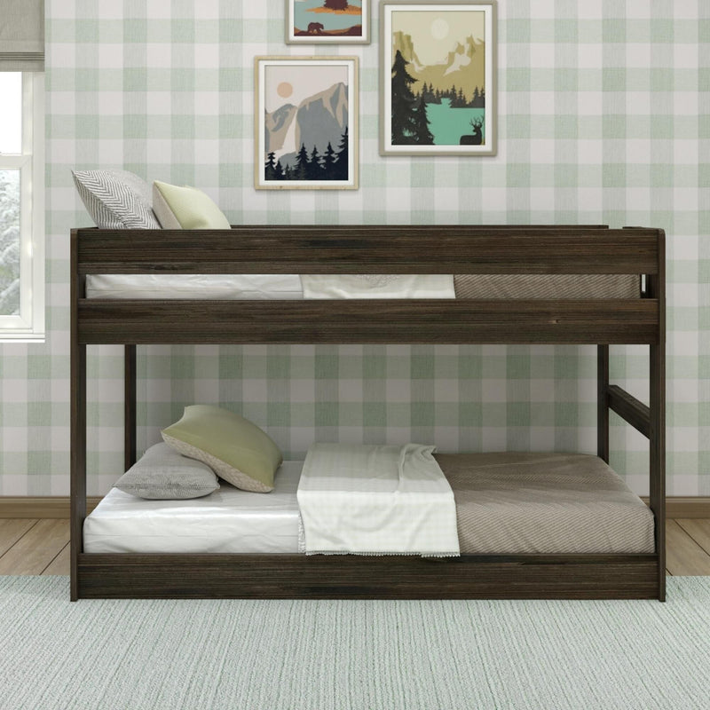 Dark wooden bunk bed in a cozy kids bedroom with pale green gingham wallpaper, neutral bedding and framed nature prints