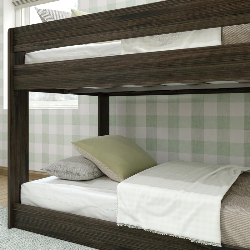 Dark wood twin-over-twin bunk bed with white and green bedding and pillows in a modern farmhouse kids bedroom with green plaid wallpaper
