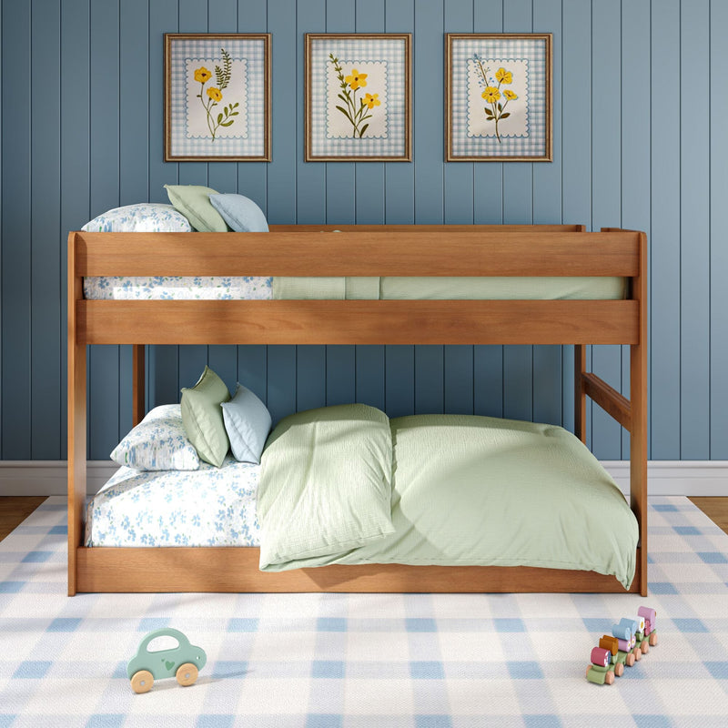 Wooden bunk bed in a blue kids bedroom with pastel green floral bedding, framed botanical prints, checkered rug and wooden toys