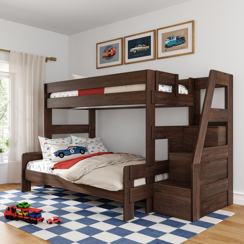 Dark wood twin-over-twin bunk bed with stairs in kids' bedroom, car-themed bedding and pillows, framed vintage car prints above, blue check rug and toy cars.
