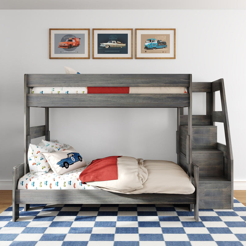 Gray wooden kids bunk bed with car-print bedding and pillows, red throw, three framed vintage car prints and blue checkered rug