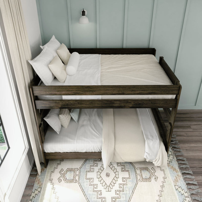 Dark wood bunk bed with white linens and neutral pillows against a pale blue board-and-batten wall in a cozy coastal-style bedroom