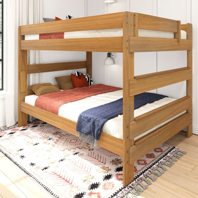 Solid wood twin-over-twin bunk bed in natural oak finish with guardrails, cozy pillows and throws on patterned rug in a modern kids' bedroom