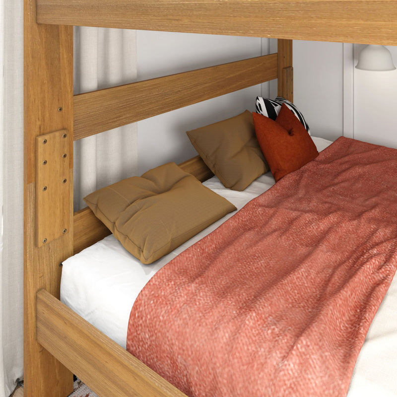 Close-up of a natural wood bunk bed with tan pillows, black-and-white accent pillow and coral textured blanket in a cozy modern farmhouse bedroom