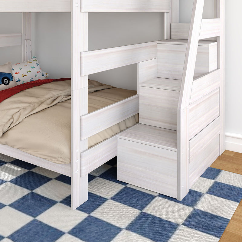 Whitewashed wooden bunk bed with built-in storage staircase, beige bedding, toy-car pillow and blue checkered rug in a kids' bedroom