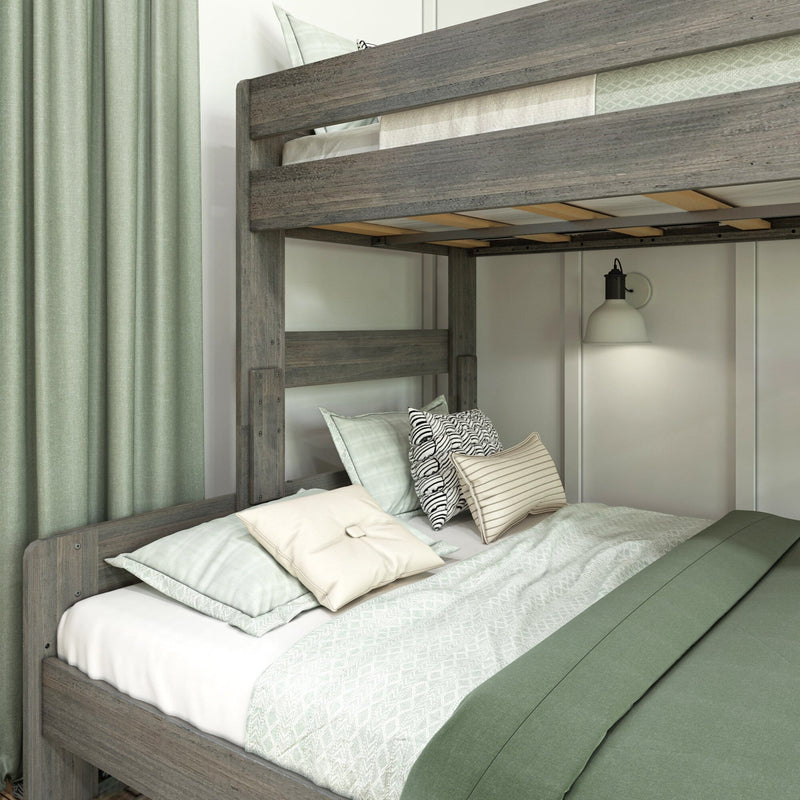 Rustic gray wooden bunk bed with green duvet, patterned and striped decorative pillows, wall sconce and matching green curtains in a modern bedroom