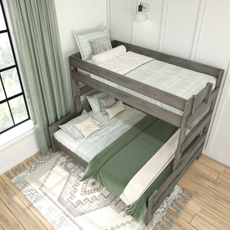 Rustic gray wooden bunk bed with sage green bedding, patterned throw pillows and rug in a bright modern farmhouse bedroom next to a large window and wall sconce