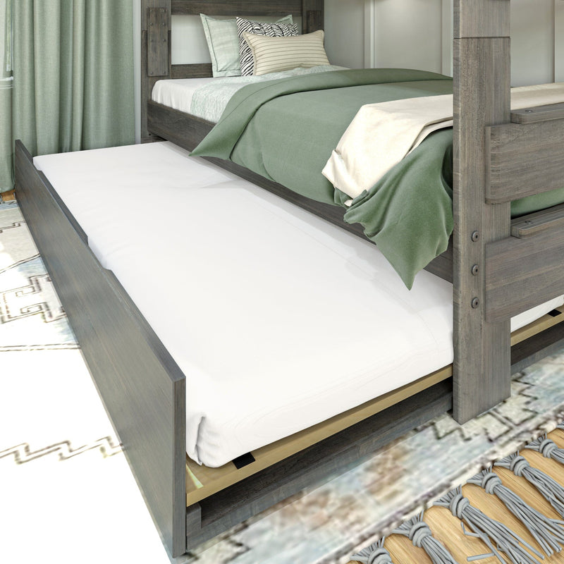 Grey wood trundle bed with pull-out twin mattress, sage green bedding and striped pillows — space-saving guest or kids' room solution