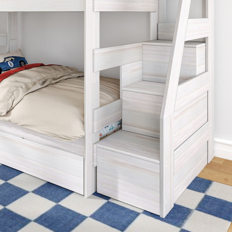 Whitewashed wooden bunk bed with built-in storage stairs and under-bed drawers, lower twin mattress with beige bedding and blue checkered rug in children's bedroom
