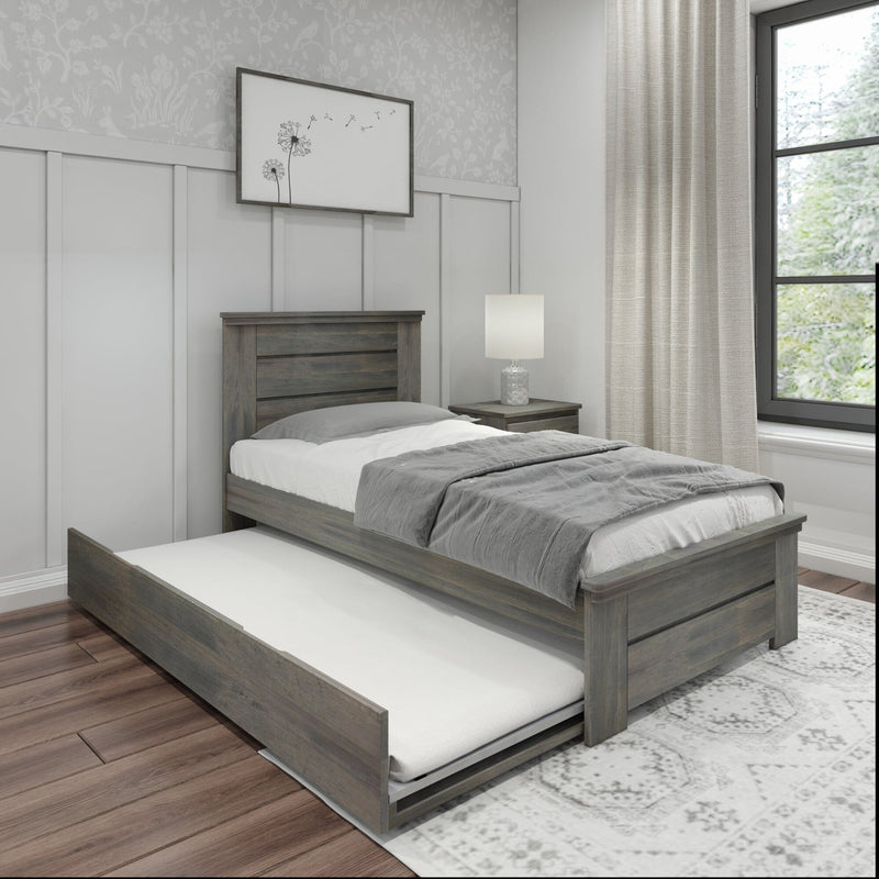 Gray wooden trundle bed with gray bedding, nightstand lamp and framed dandelion art in a modern farmhouse bedroom with paneled accent wall and window
