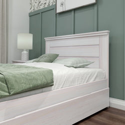Elegant white wooden bed frame with green bedding in a modern bedroom with decorative wall paneling.
