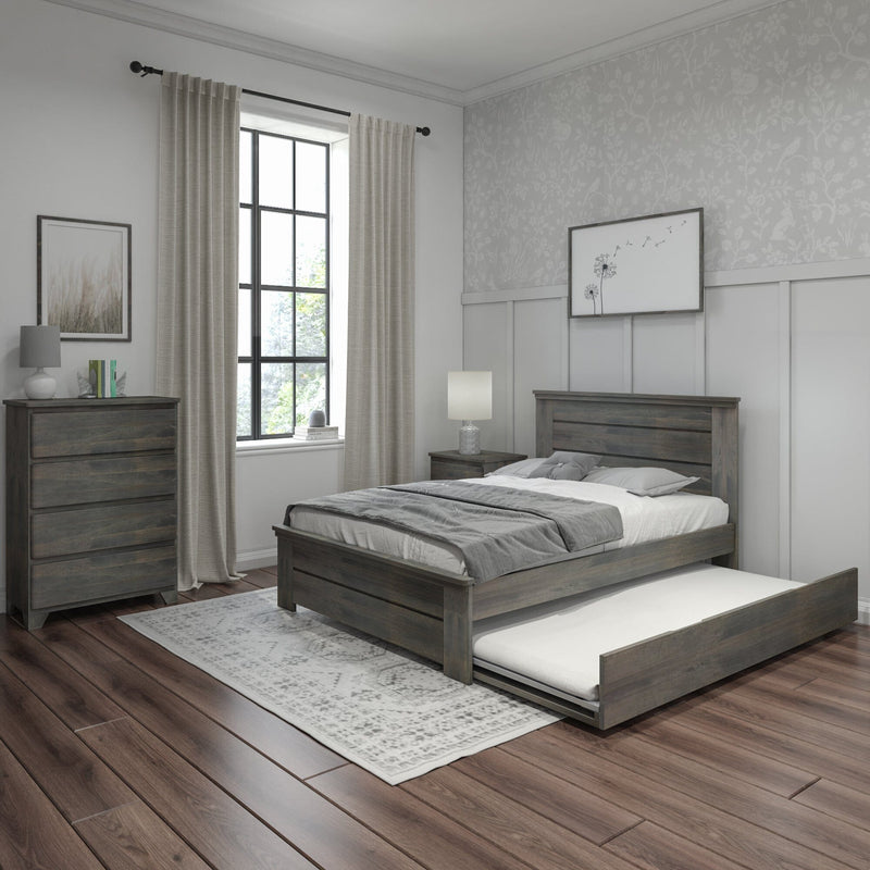 Modern farmhouse bedroom with grey wooden bed and pull-out trundle, matching dresser, neutral bedding, linen curtains framing a black-framed window, floral wallpaper accent, bedside lamp and dark hardwood floors