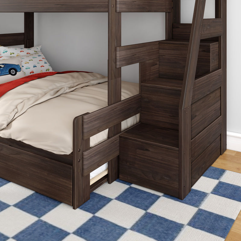 Dark walnut kids bunk bed with built-in storage stairs, beige bedding and car-print pillow on blue check rug