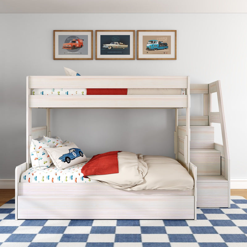 Light wood kids bunk bed with car-themed bedding, red throw, staircase storage drawers, framed vintage car prints and blue check rug
