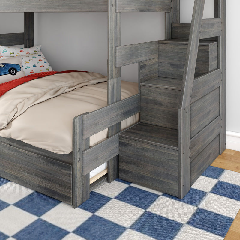 Gray twin-over-twin bunk bed with built-in storage stairs, beige bedding and car-print pillow in kids' bedroom on blue check rug