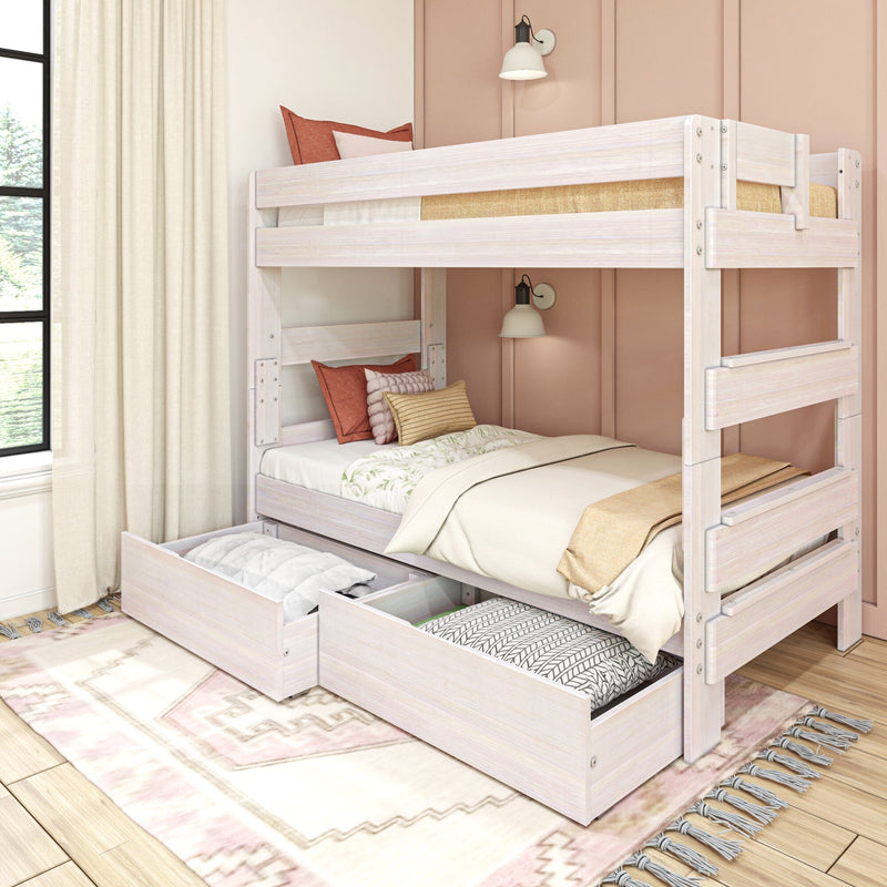 Whitewashed wooden bunk bed with under-bed storage drawers and trundle, neutral bedding and rust pillows in cozy kids room with boho rug and wall sconce