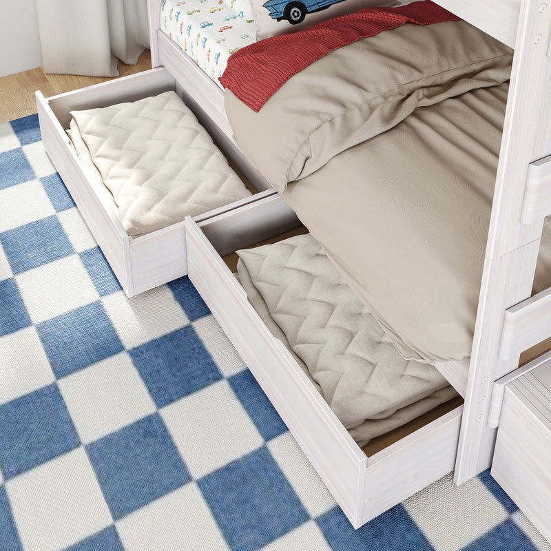 White wooden kids bunk bed with under-bed pull-out storage drawers holding folded quilts, beige bedding and blue checkered rug