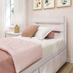 Cozy pink-themed bedroom with a plush bed, decorative pillows, modern wall art, and natural lighting.