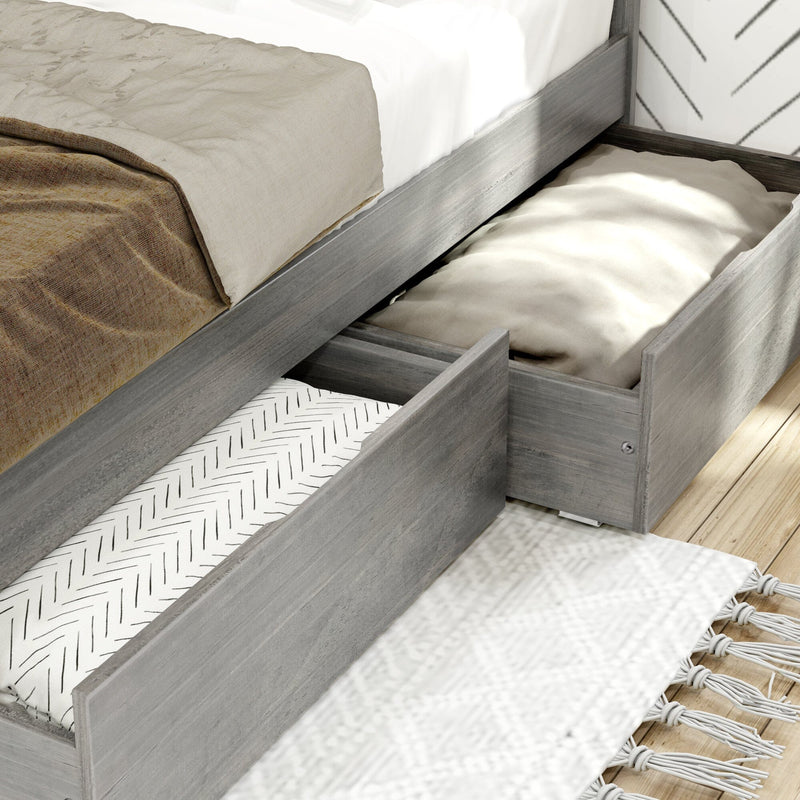 Grey wood platform bed with built-in under-bed storage drawers pulled out revealing folded blankets and pillows, modern bedroom storage and organization solution
