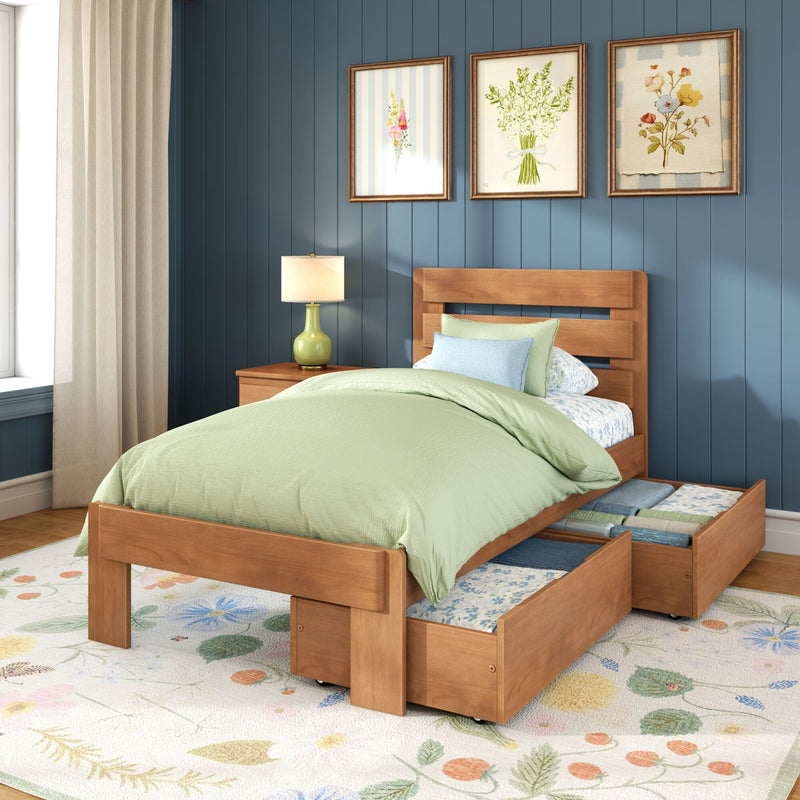 Wooden twin storage bed with pull-out drawers, sage green bedding and pillows, bedside lamp and floral framed art on blue paneled accent wall