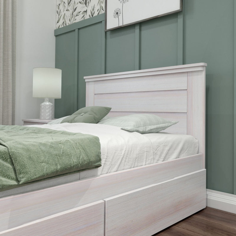 Modern bedroom close-up with whitewashed wood bed frame, sage green board-and-batten accent wall, green bedding and bedside lamp
