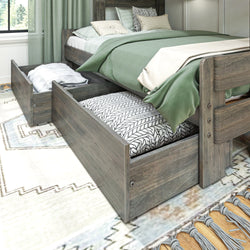 Wooden bed with green bedding and under-bed storage drawers open in a modern bedroom.
