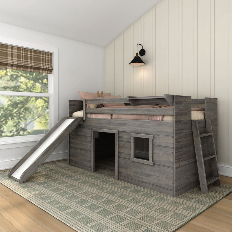 Gray wooden kids loft bed with slide and playhouse lower level in farmhouse-style bedroom with board-and-batten wall, black sconce, and plaid Roman shade