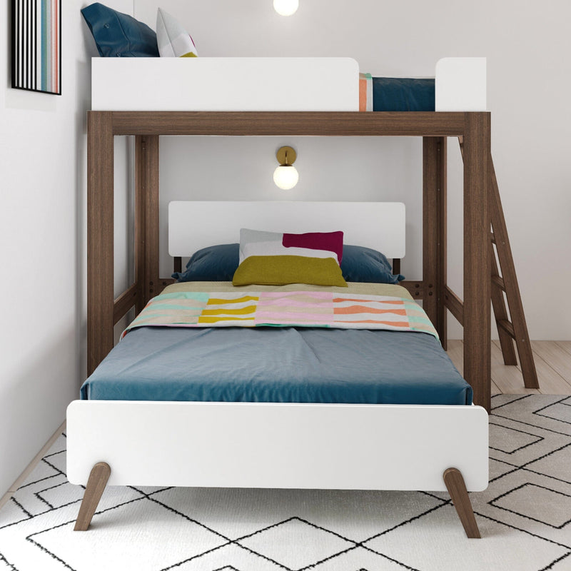 Modern twin-over-twin bunk bed with walnut wood frame, white guardrails and ladder, teal bedding and colorful pillows with pastel striped blanket in a children's bedroom