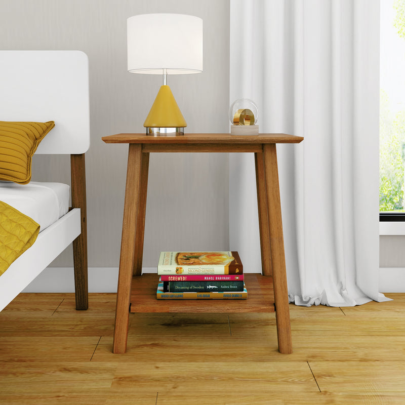 Modern wooden bedside table and nightstand decor with yellow cone table lamp, glass orb accent, stacked books and white bed with mustard yellow pillow in a minimalist bedroom