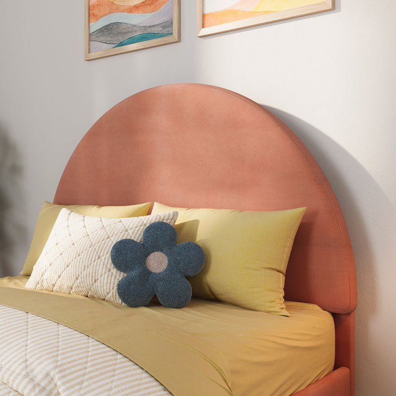 Coral pink round upholstered headboard with yellow bedding, quilted pillows and blue flower-shaped throw pillow in modern bedroom decor with abstract wall art