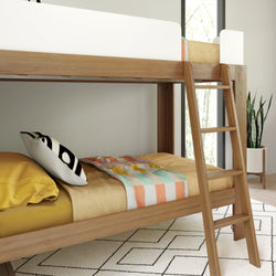 Modern wooden bunk bed with colorful bedding and indoor plant in bright room.