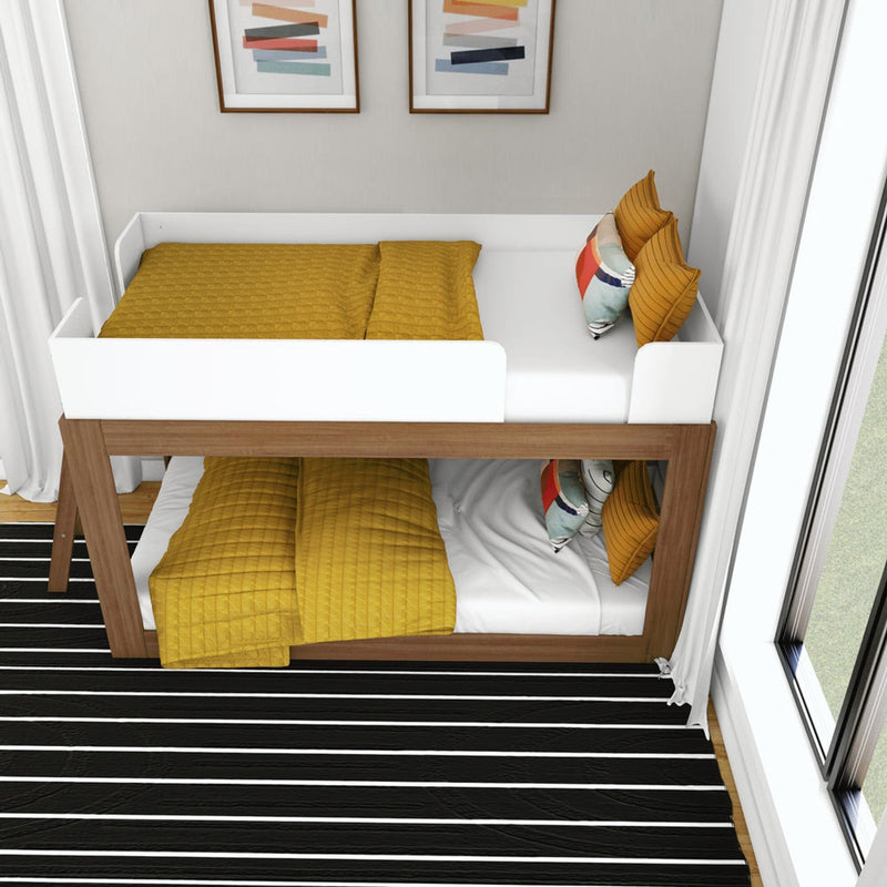 Modern wooden bunk bed with white guard rails and mustard-yellow quilted bedding, colorful accent pillows in a bright kids' bedroom with black-and-white striped rug and large window