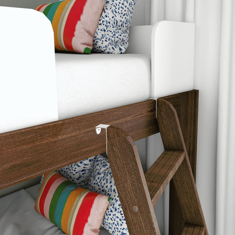 Close-up of wooden bunk bed ladder and white bed rail with mattress, rainbow-striped pillow and blue floral cushion in a kids' bedroom