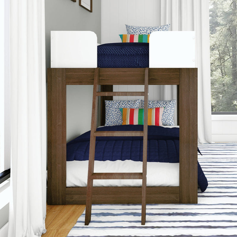 Dark wood bunk bed with ladder, navy quilted bedding, white safety rails and multicolor striped pillows in a bright modern kids' bedroom with white curtains and striped rug
