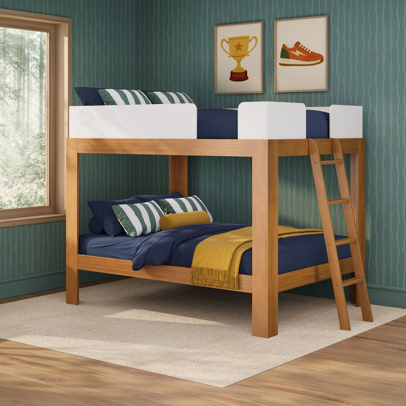 Wooden bunk bed for kids with navy bedding, green striped pillows and mustard throw in a teal wavy wallpapered room with framed trophy and sneaker art and a window forest view