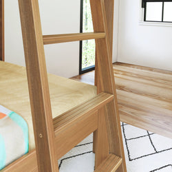 Wooden ladder leading to a cozy bunk bed in a modern, minimalist bedroom with natural light and wooden flooring.