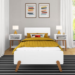 Modern bedroom interior design with white bed frame, mustard yellow bedding, contemporary nightstands, and abstract wall art.