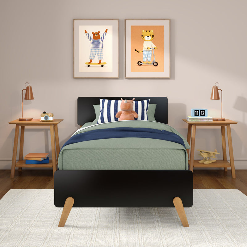 Modern kids bedroom with green bedding, striped pillow and plush rhino, wooden nightstands with copper lamps, toy camera and blue flip clock, plus two framed animal prints (bear on skateboard, tiger on scooter) — nursery wall art and children's room decor
