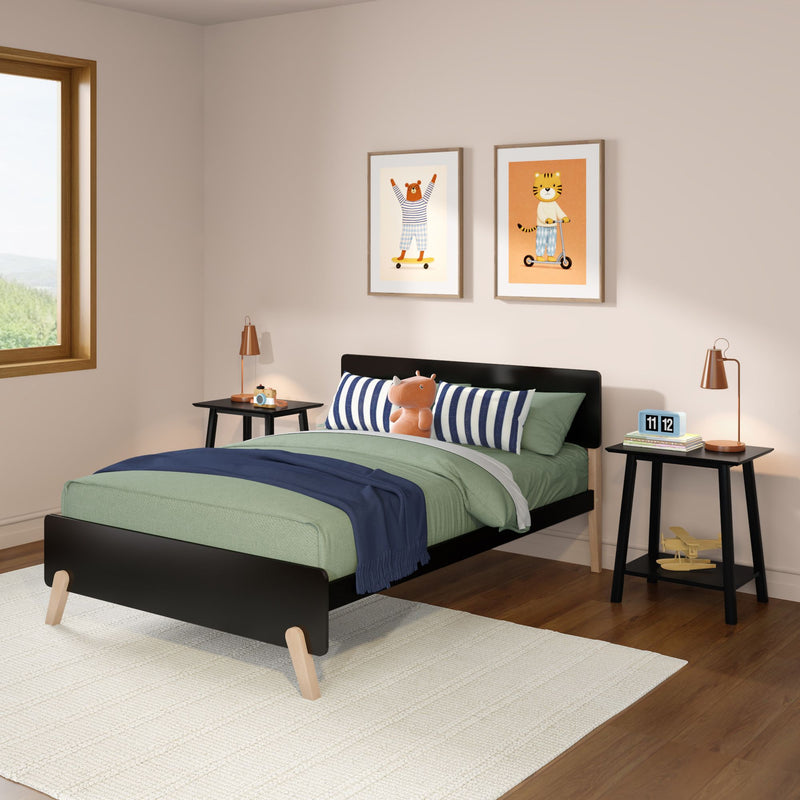 Modern children's bedroom interior with black twin bed, green bedding and navy throw, striped pillows, stuffed toy, nightstands with copper lamps and animal wall art