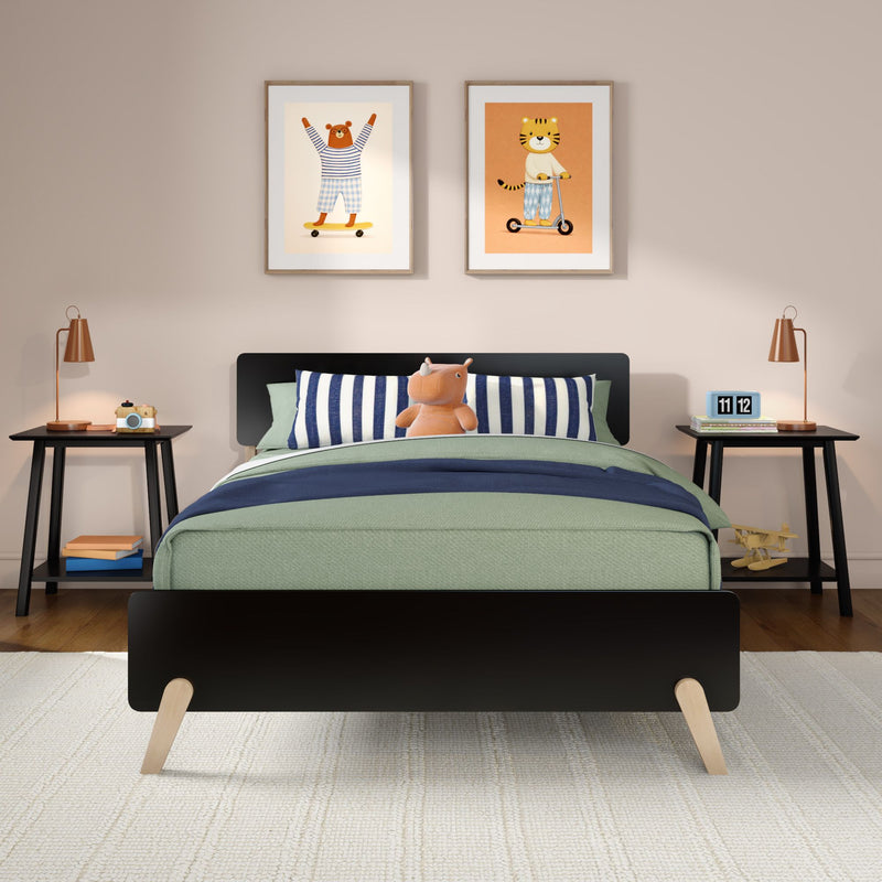 Modern kids bedroom with single black bed, green and navy bedding, striped pillows, plush hippo toy, animal framed wall art, wooden nightstands and copper lamps