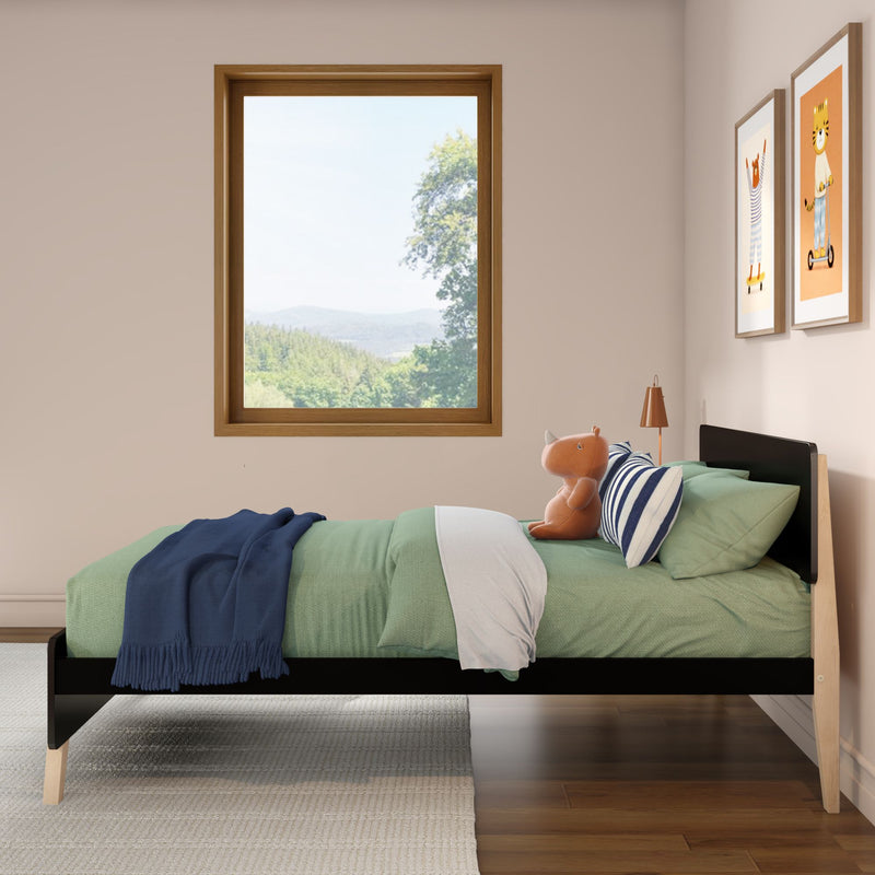 Modern children's bedroom with single wooden bed, green bedding, navy throw, striped pillow, plush toy, window with forest view and framed animal prints