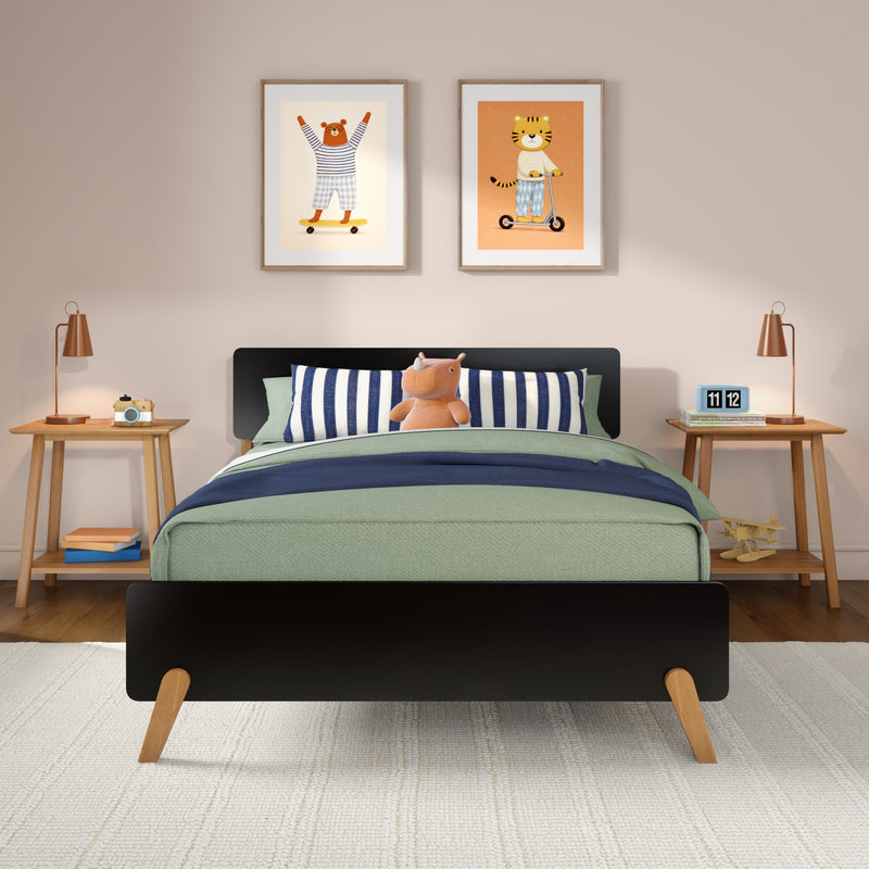 Kids bedroom with black bed, green comforter, navy striped pillows, plush hippo toy, wooden nightstands, animal wall prints