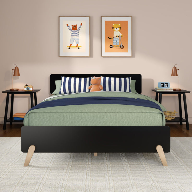 Modern kids bedroom nursery with green bedding, navy striped pillows, plush hippo toy, framed animal wall art and bedside lamps