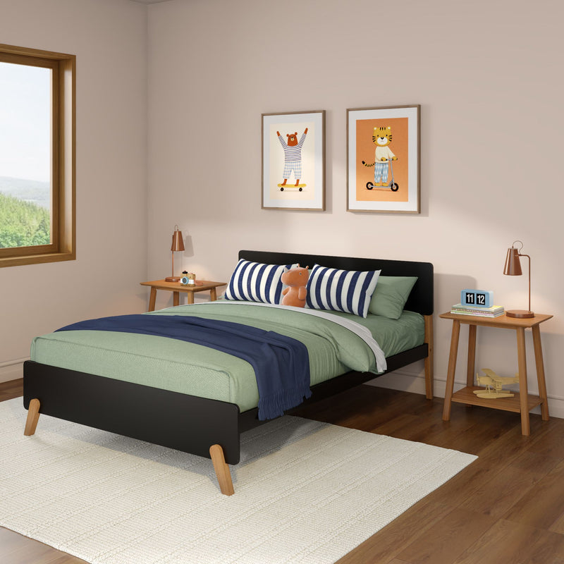 Children's bedroom with green duvet, navy-striped pillows, plush toy, wooden bed and nightstands, copper lamps and framed animal prints by a sunny window — modern kids room decor