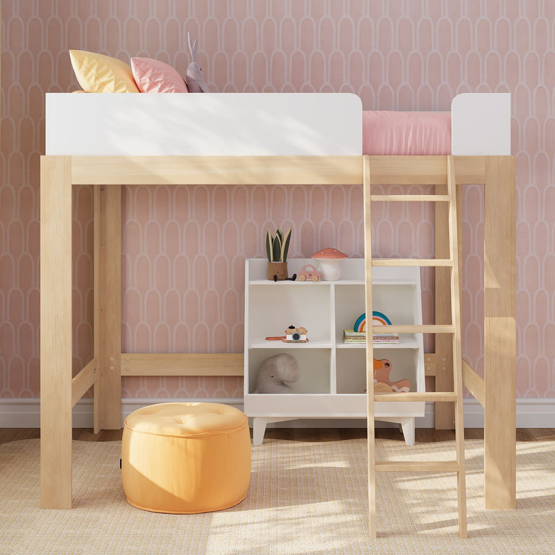 Wooden kids loft bed with white guardrail and ladder in pastel pink children's bedroom, patterned wallpaper, under-bed storage cubbies, toys and orange pouf