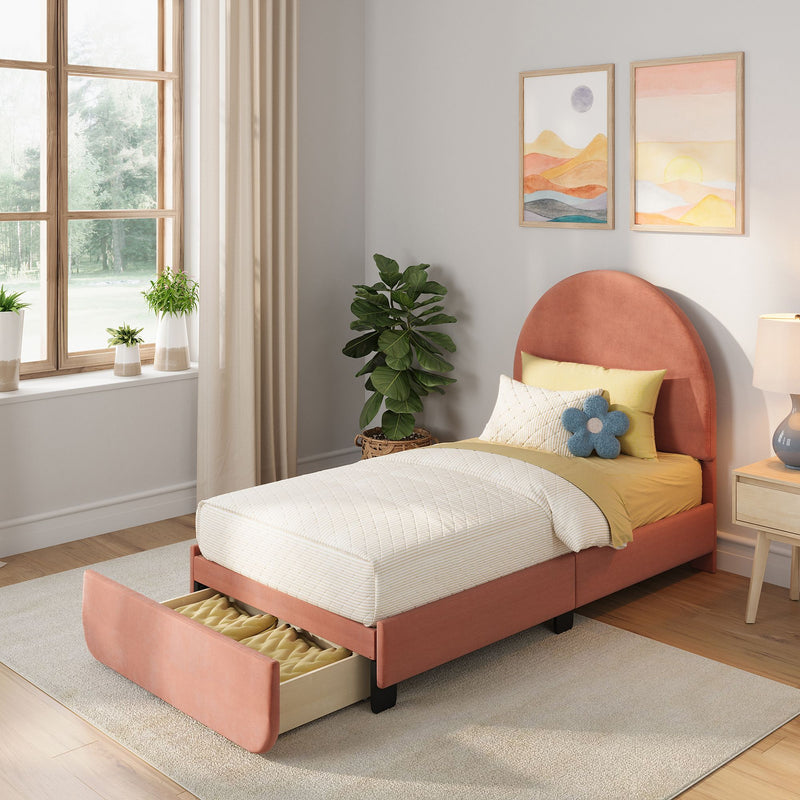 Cozy modern kids bedroom featuring a blush pink upholstered twin bed with open under-bed storage drawer, cream quilted bedding and yellow accent pillow, potted plants on a wood-framed window with beige curtains, pastel framed wall art and bedside lamp